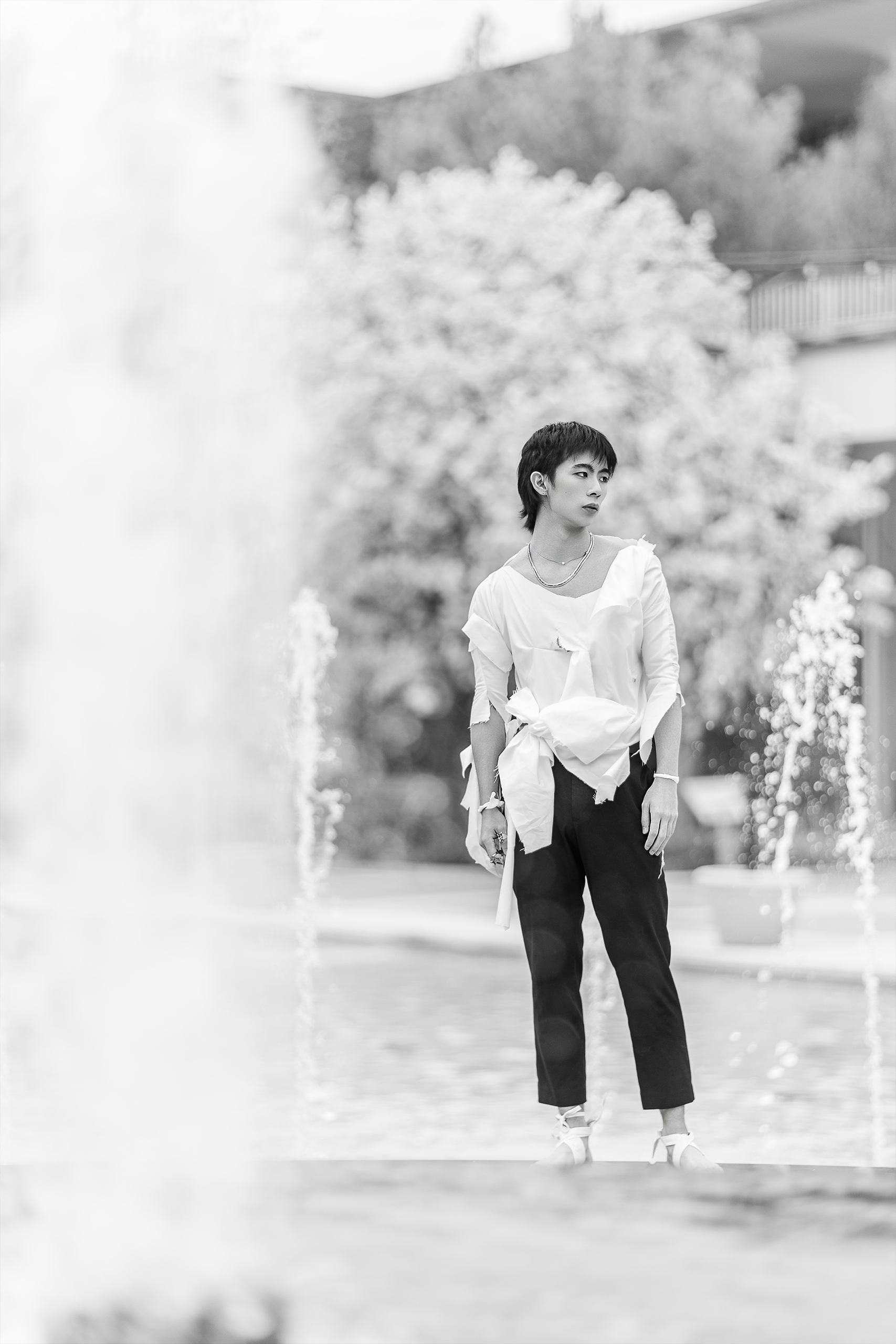 man standing in front of numerous water fountains with torn clothing