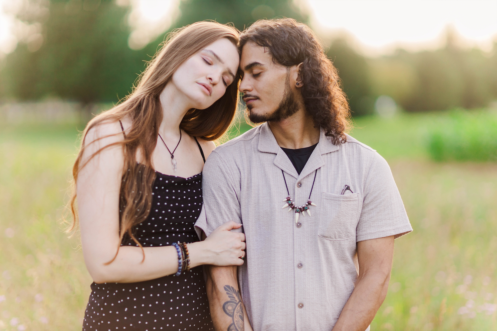 coupe embracing each other in park with greenery and sunset glow