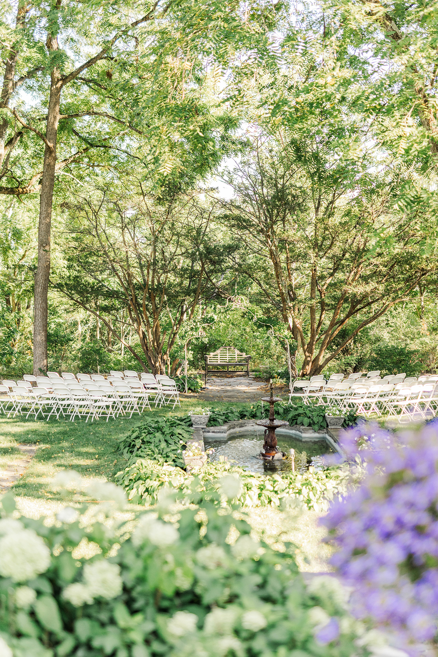 ceremony space with tall trees arch fountain and foreground with flowers