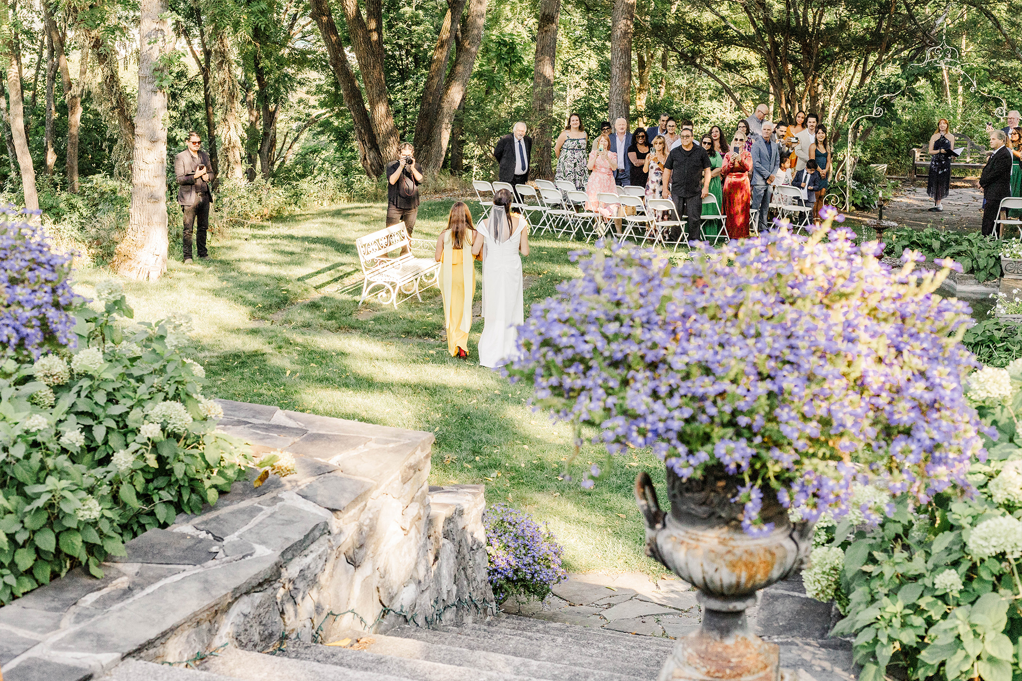 bride and maid of honor walking toward guests and ceremony space