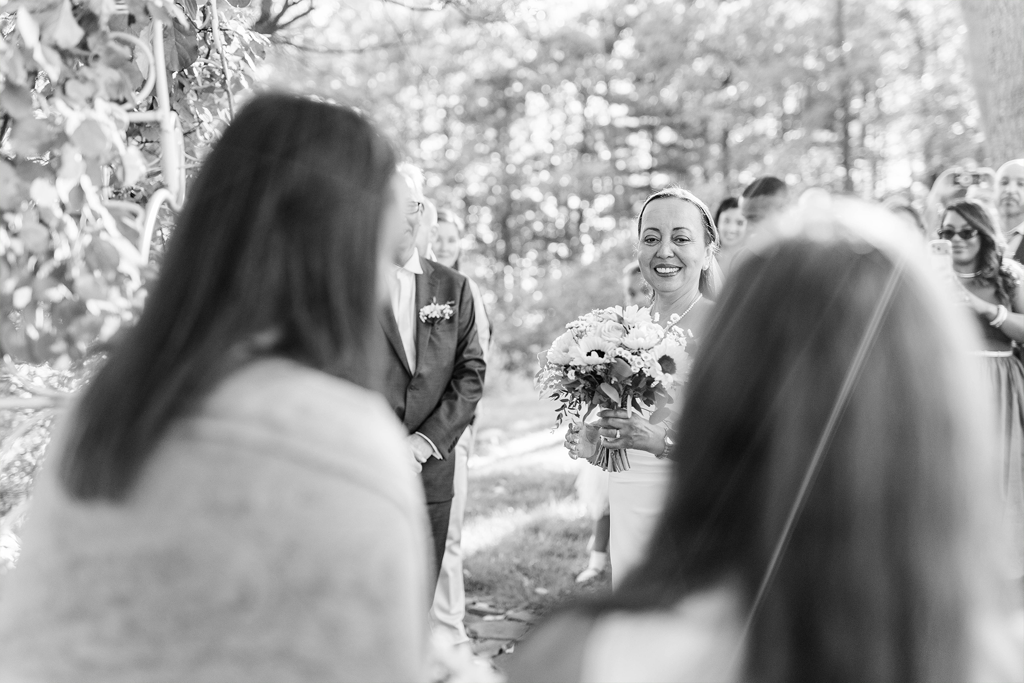 bride walking up to wedding arch with guests and greedy