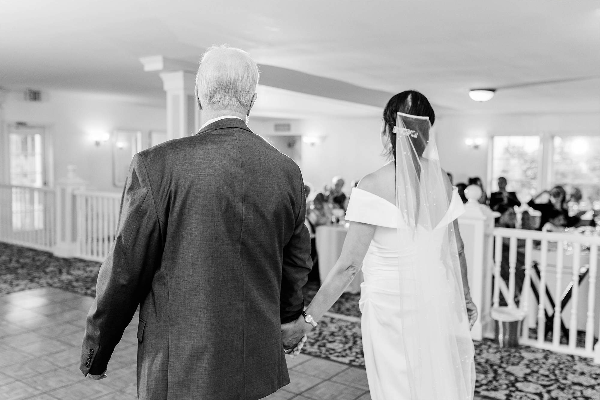 bride and groom entering wedding reception with onlooking guests