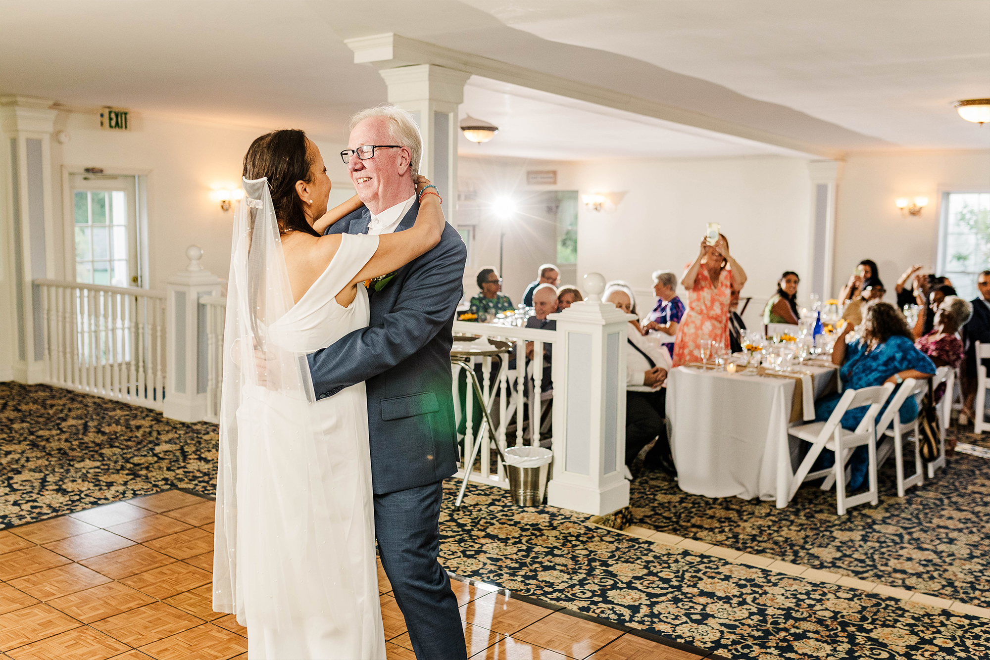 bride and groom dancing with each other on dance floor with on looking guests