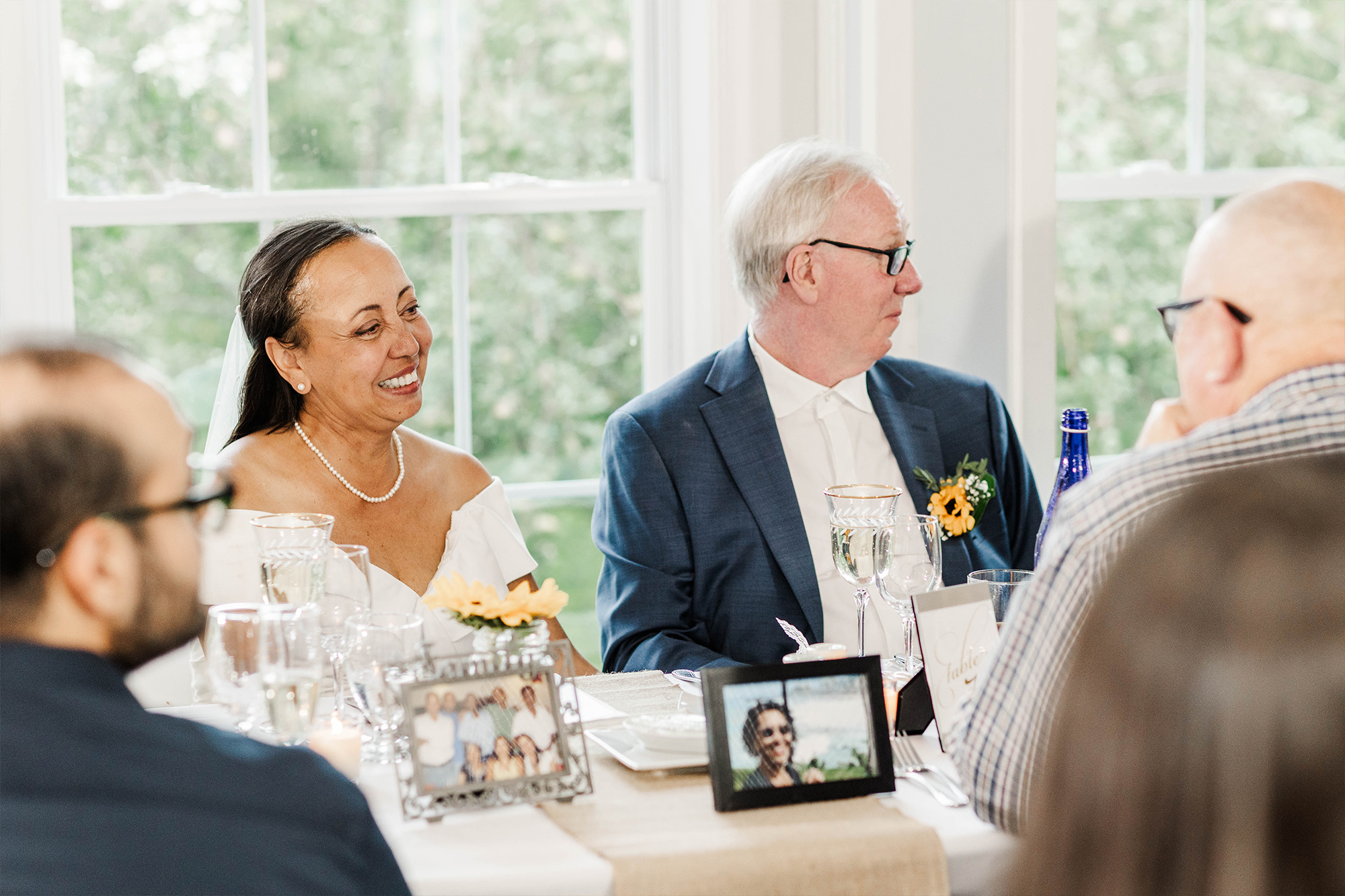 bride and groom seated at dinner table with guests