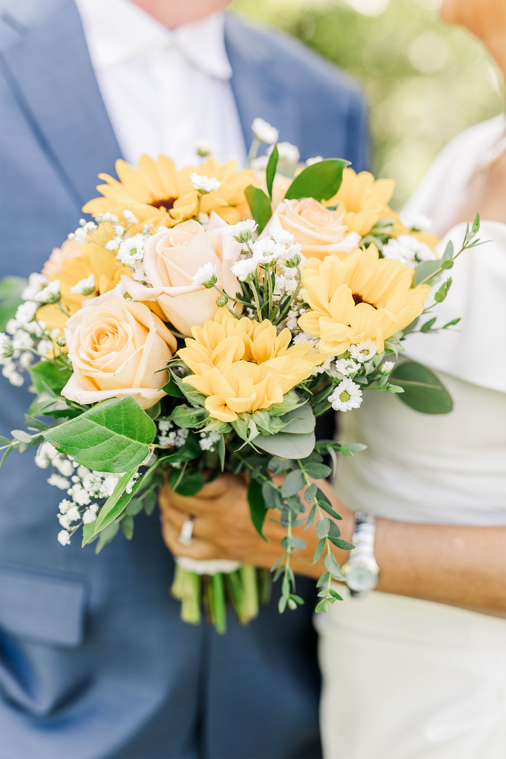 bridal bouquet detail shot with roses babies breath greenery and sunflowers