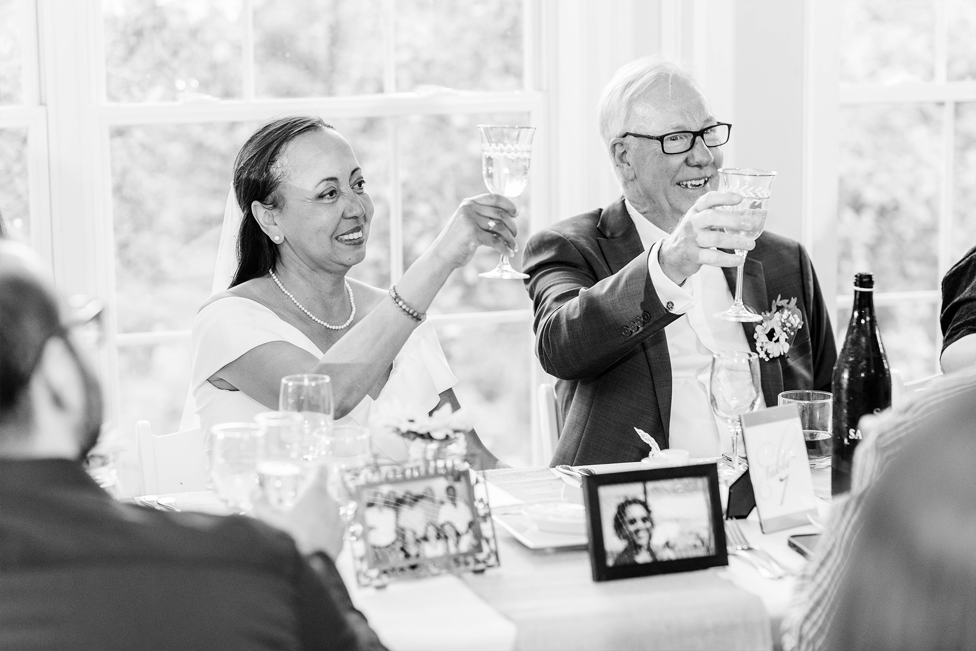 bride and groom raising their glasses and toasting their guests